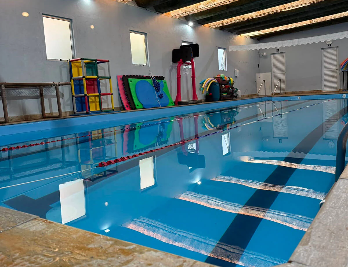 Piscina da Academia Filipina com brinquedos e materiais de natação infantil ao fundo